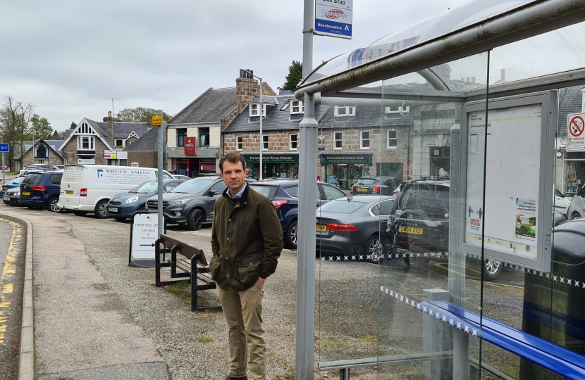 Andrew beside a bus stop.