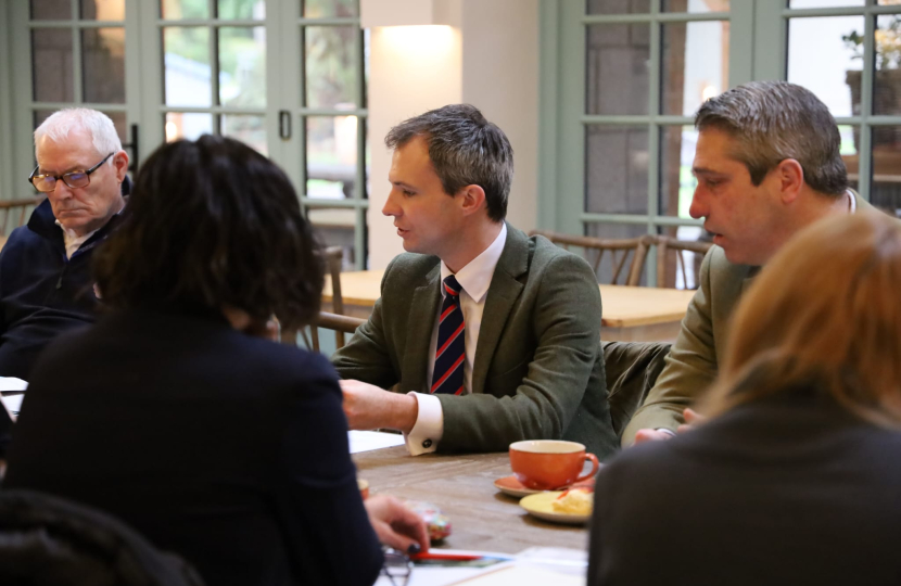 Andrew Bowie MP sitting at a table with representatives of Scotland's Veterans charities.